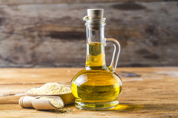 Sesame seeds and bottle with oil on a old wooden table,Sesame oi